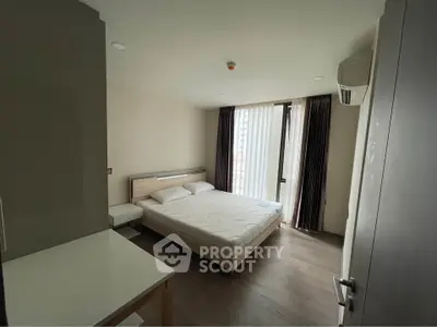 Modern bedroom with large window and minimalist design in a high-rise apartment.