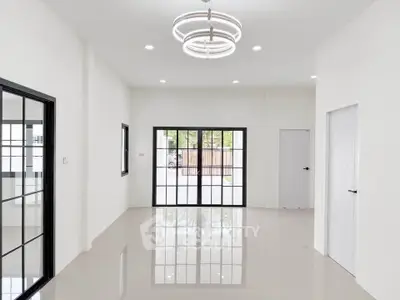 Spacious modern living room with large windows and elegant lighting