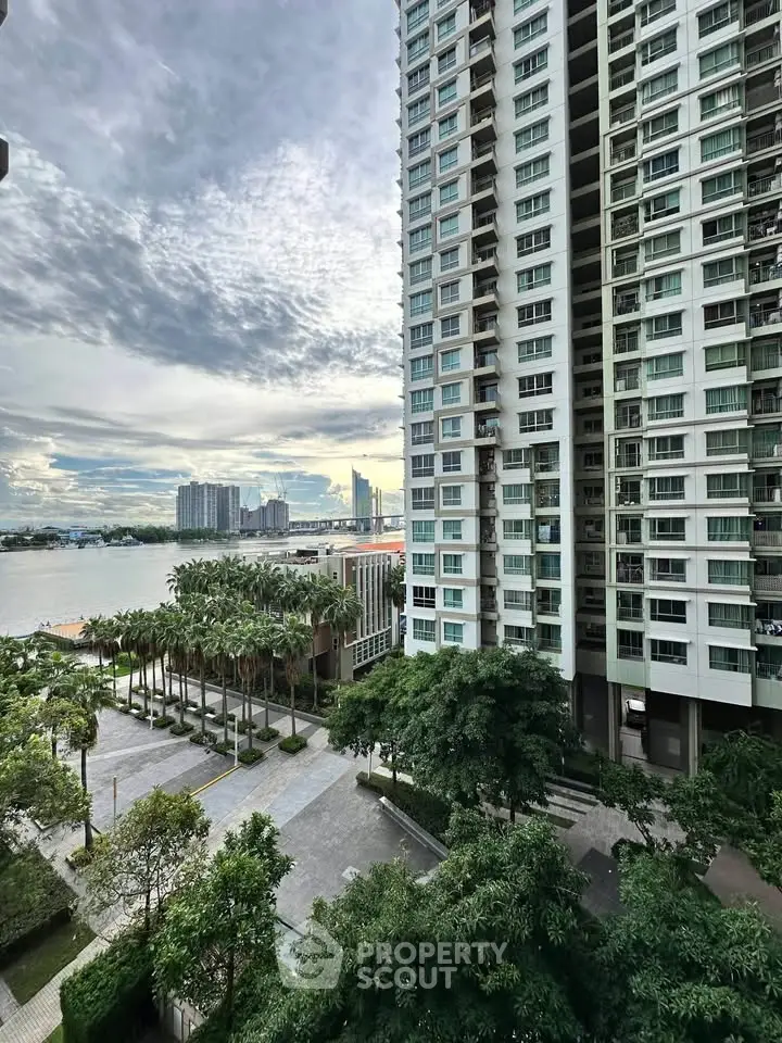 Stunning high-rise building with river view and lush greenery, perfect for urban living.