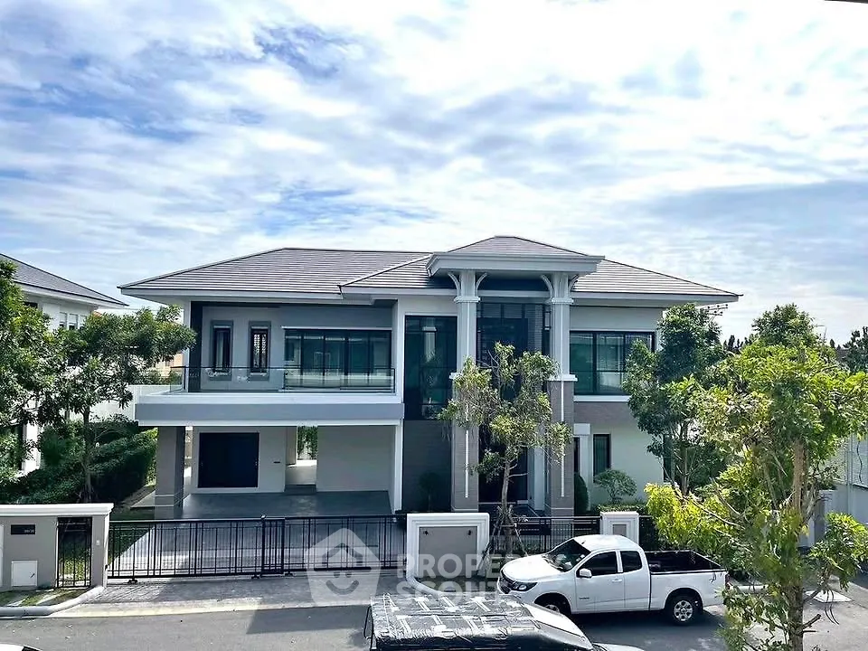 Stunning modern two-story house with spacious driveway and lush greenery, perfect for luxurious living.
