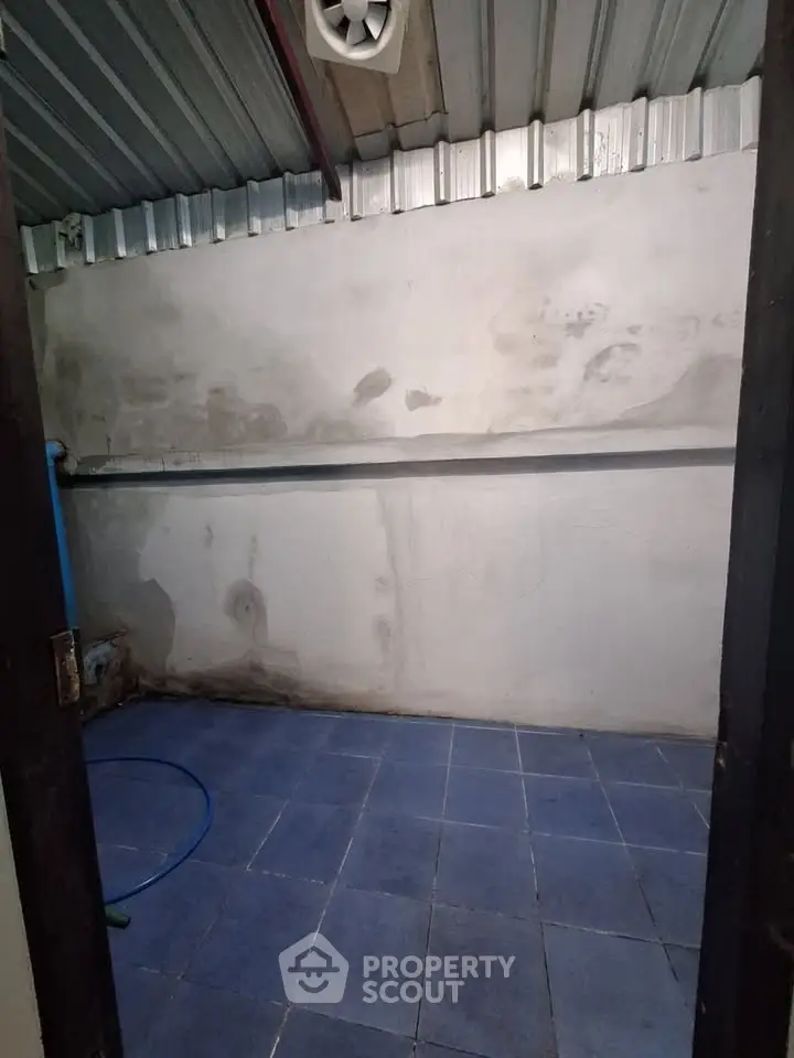 Spacious storage room with tiled floor and ventilation, ideal for organizing household items.