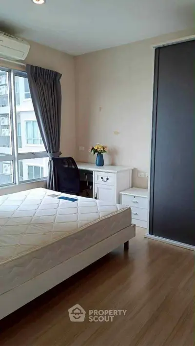 Bright bedroom with large window and modern furniture in urban apartment