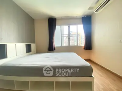 Spacious bedroom with large window and modern design in a bright apartment.