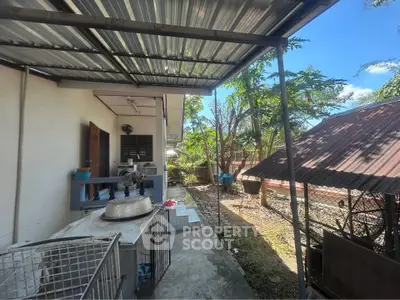 Charming outdoor space with covered patio and lush greenery, perfect for relaxation and entertaining.