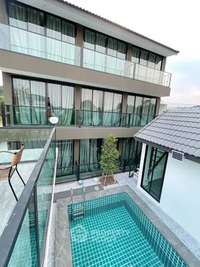 Modern multi-story building with private pool and glass balconies