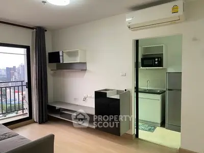 Modern apartment living room with balcony and compact kitchen view.