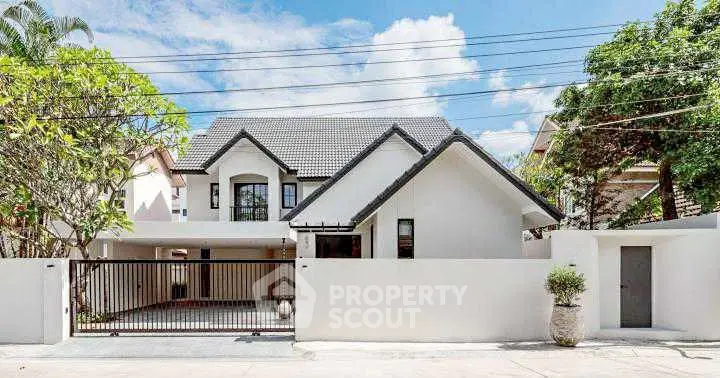 Charming modern house with gated entrance and lush greenery, perfect for family living.