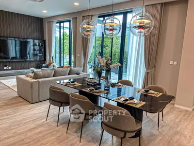 Luxurious open-plan living and dining area with modern decor and large windows offering natural light.
