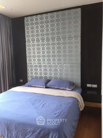 Modern bedroom with stylish headboard and cozy bedding in a contemporary apartment.