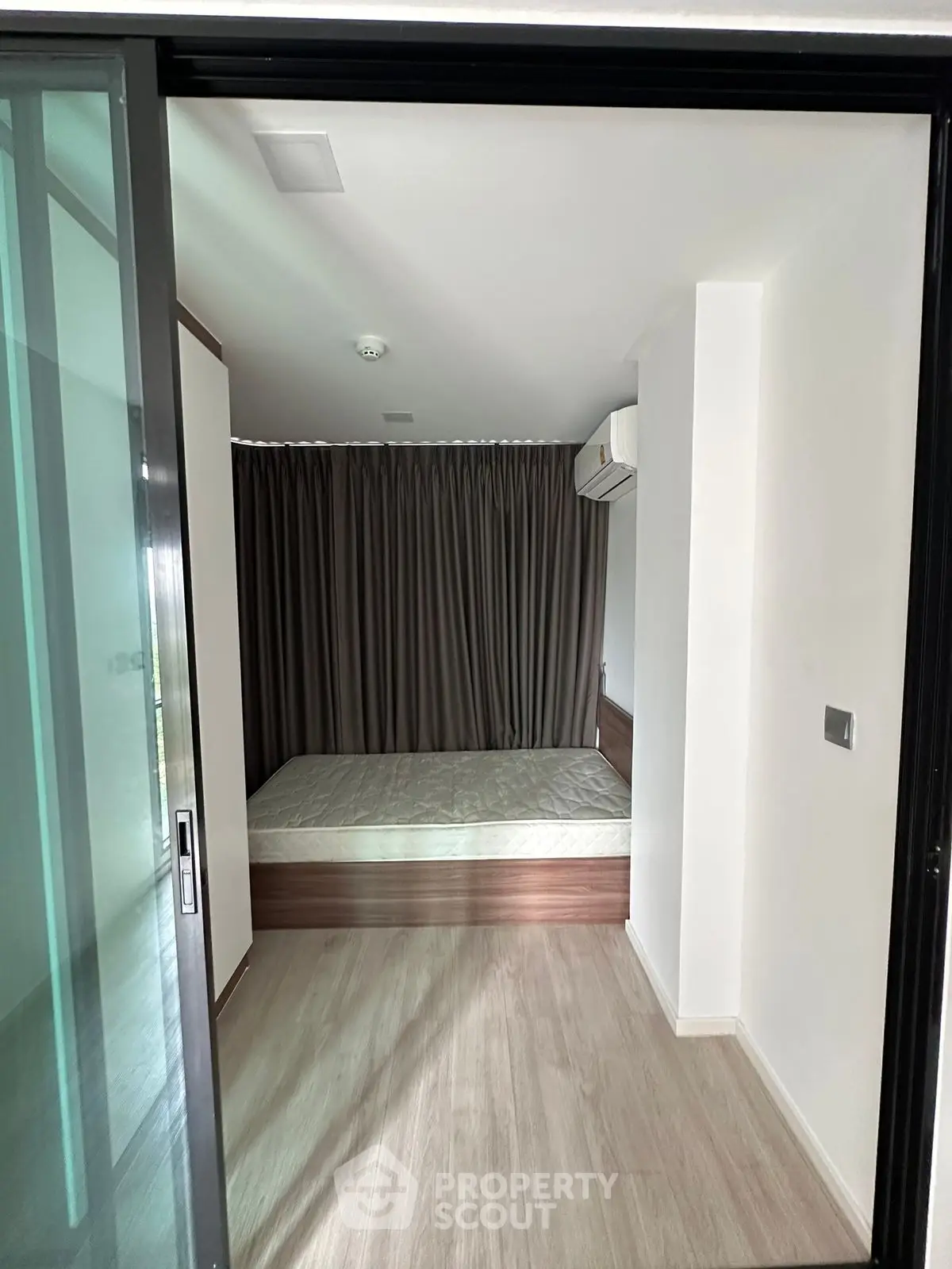 Modern compact bedroom with sliding glass door and minimalist design