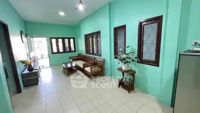 Spacious living room with vibrant green walls and wooden furniture, perfect for relaxation and gatherings.