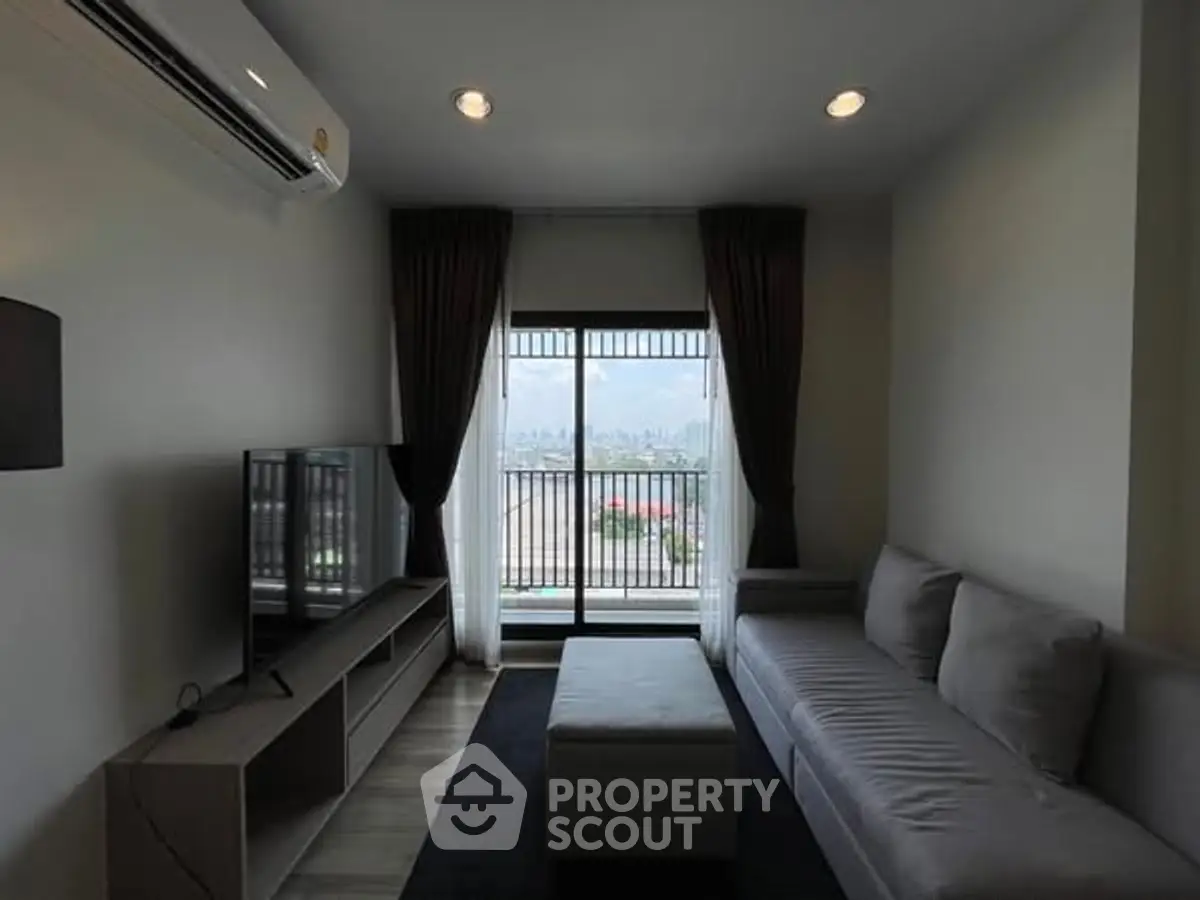 Modern living room with city view, featuring sleek furniture and large window.