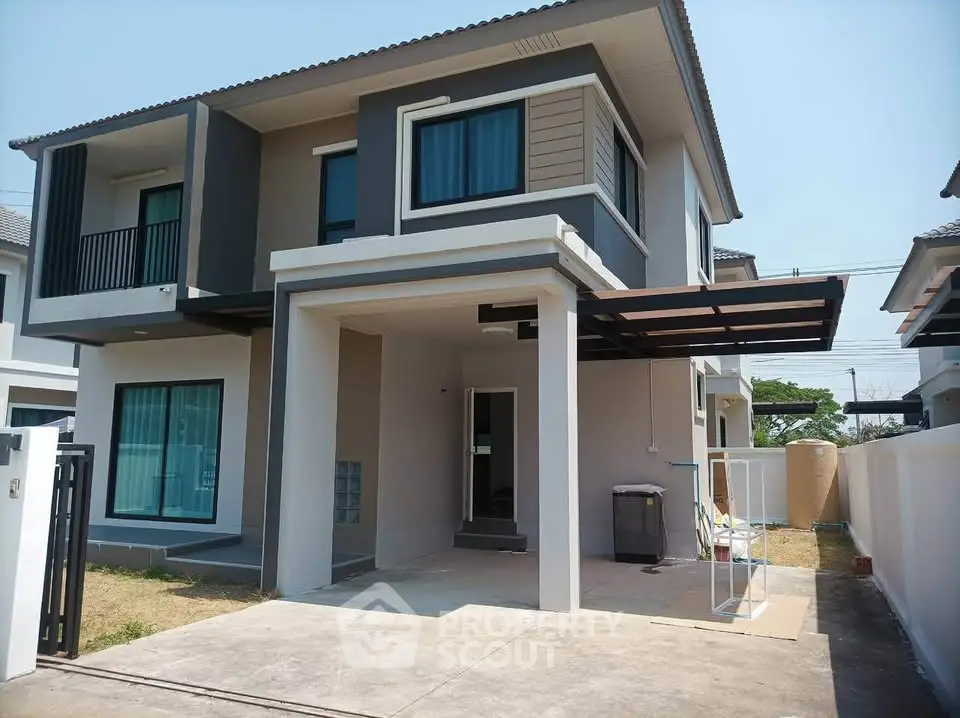 Modern two-story house with a sleek design and spacious driveway in a suburban neighborhood.