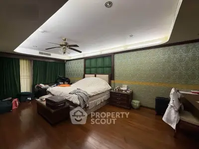 Spacious bedroom with elegant decor and wooden flooring