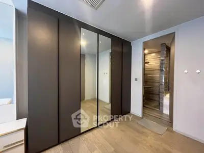 Modern bedroom with sleek mirrored wardrobe and stylish en-suite bathroom