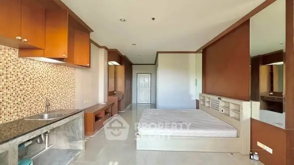Spacious studio apartment with modern kitchen and cozy sleeping area.