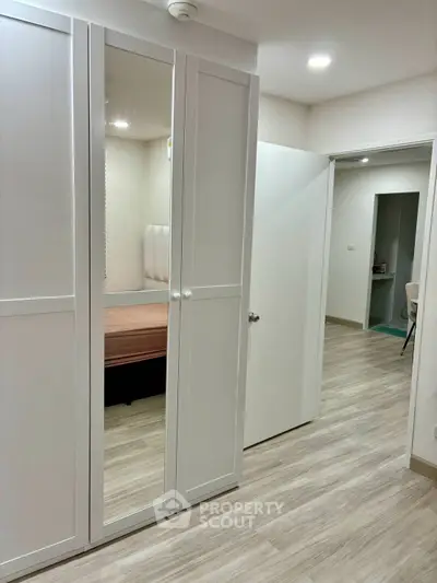 Modern apartment hallway with sleek wardrobe and wooden flooring