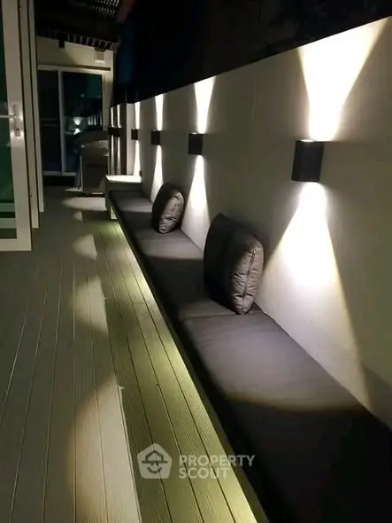 Stylish outdoor seating area with modern lighting and cozy cushions, perfect for relaxation.