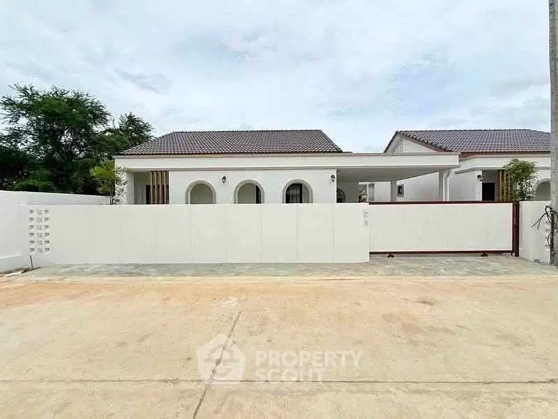 Charming white bungalow with modern design and spacious driveway in serene neighborhood.