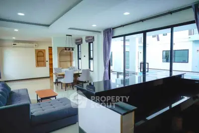Spacious modern living room with open layout and pool view