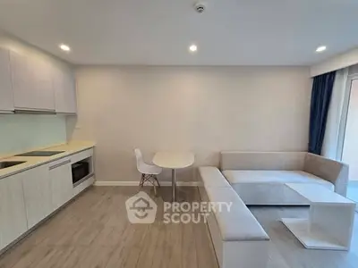 Modern open-plan living room with sleek kitchen and cozy seating area