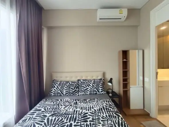 Cozy bedroom with modern decor and air conditioning in a stylish apartment.