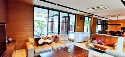 Luxurious living room with modern furniture and large windows overlooking a garden.