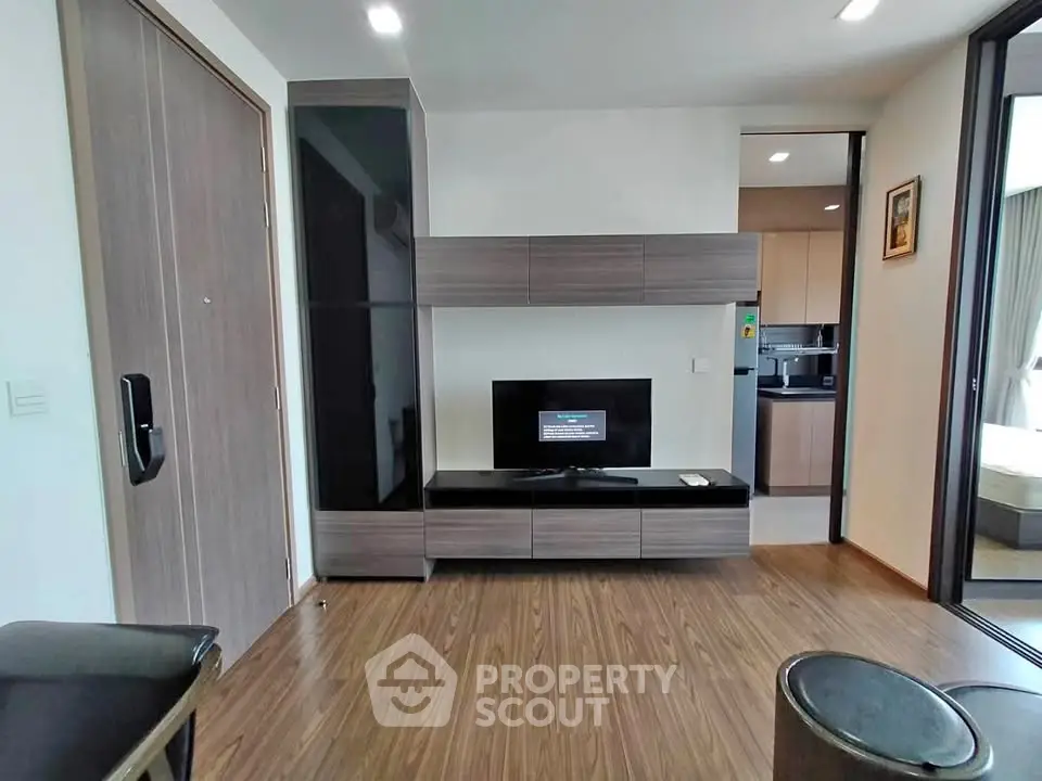 Modern living room with sleek entertainment center and wood flooring