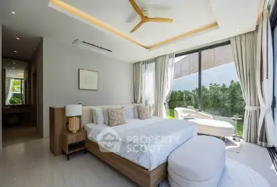 Luxurious bedroom with modern decor and large windows overlooking a private garden.