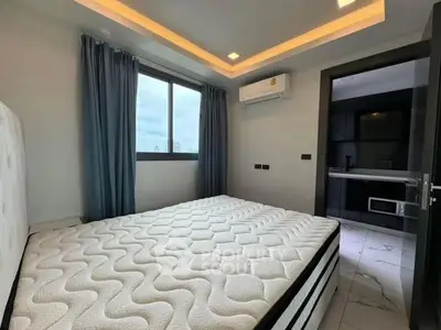 Modern bedroom with large window and ensuite bathroom, featuring sleek design and ample natural light.