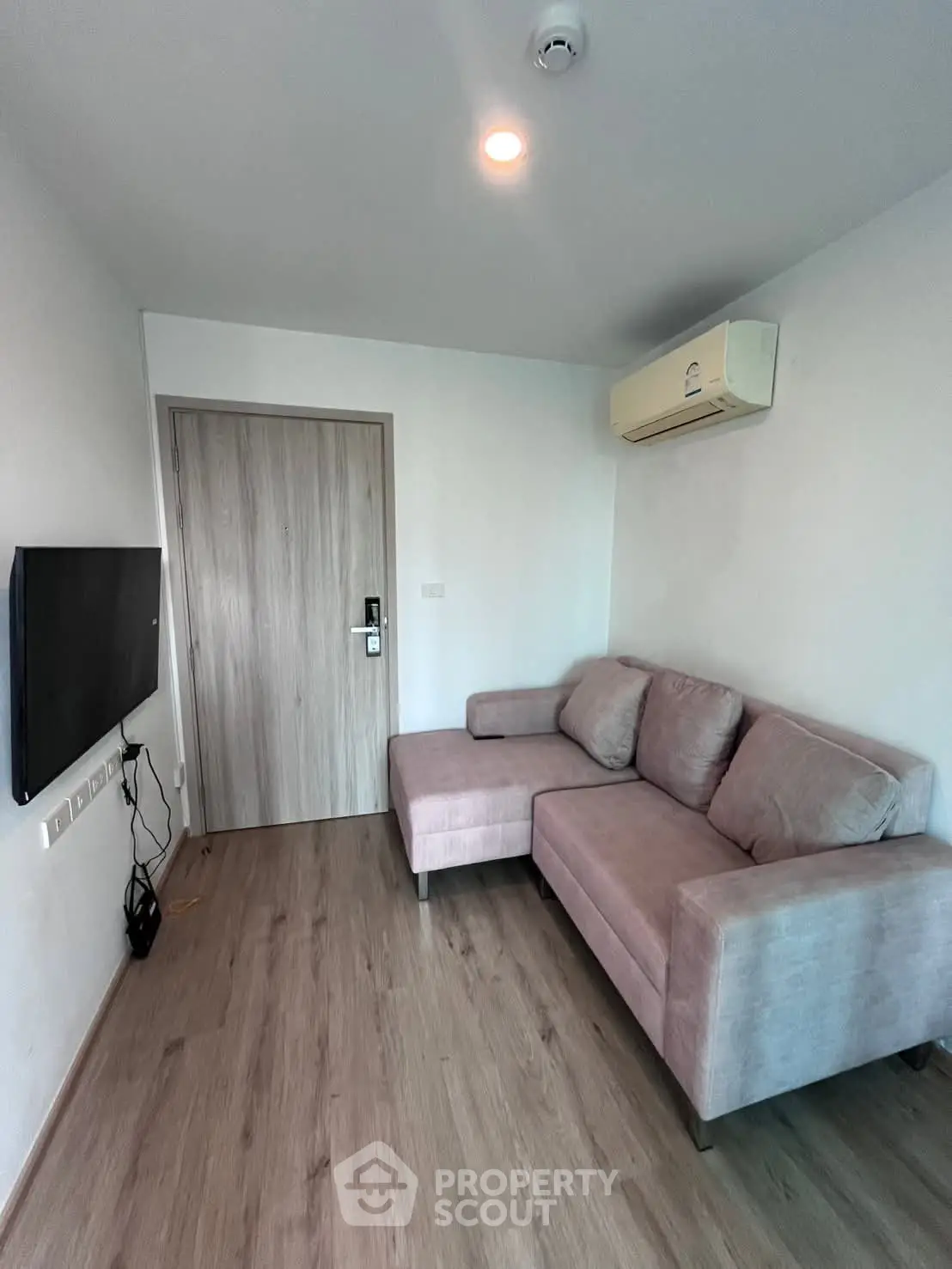 Modern living room with cozy sofa and wall-mounted TV in a stylish apartment.
