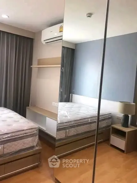 Modern bedroom with mirrored wardrobe and air conditioning in stylish apartment.