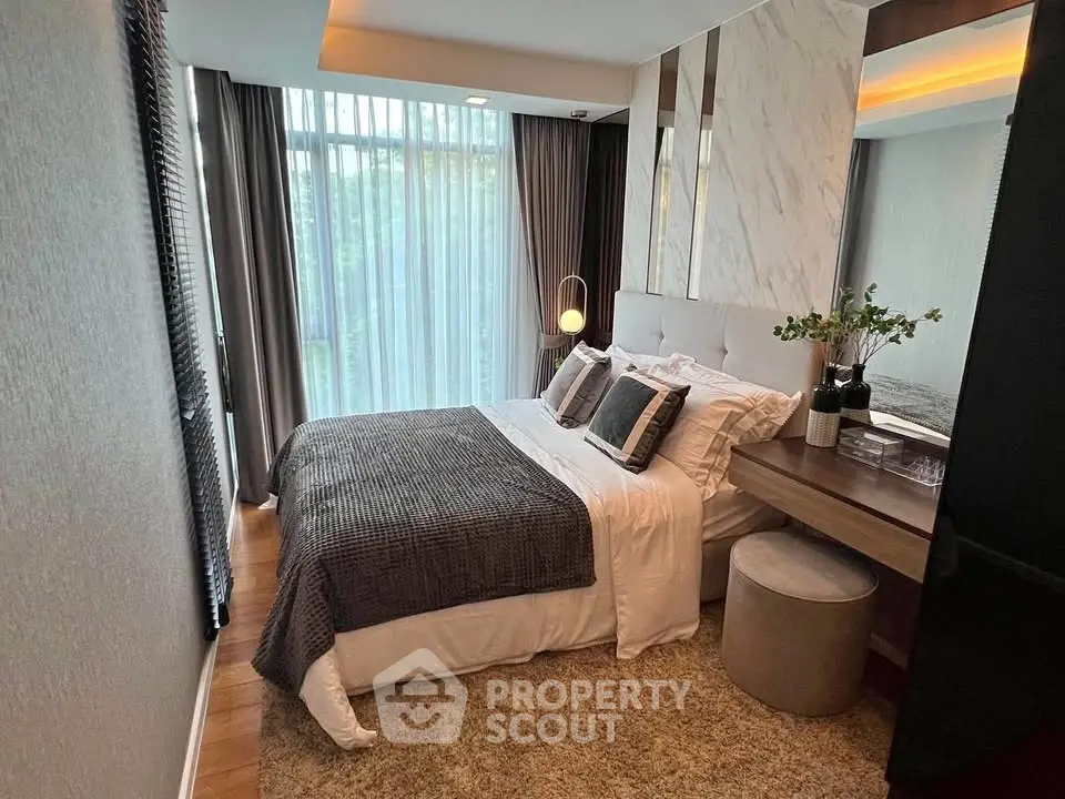 Luxurious bedroom with modern decor and large window offering natural light.
