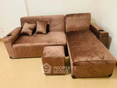 Cozy brown sectional sofa with matching ottoman in a modern living room setting.