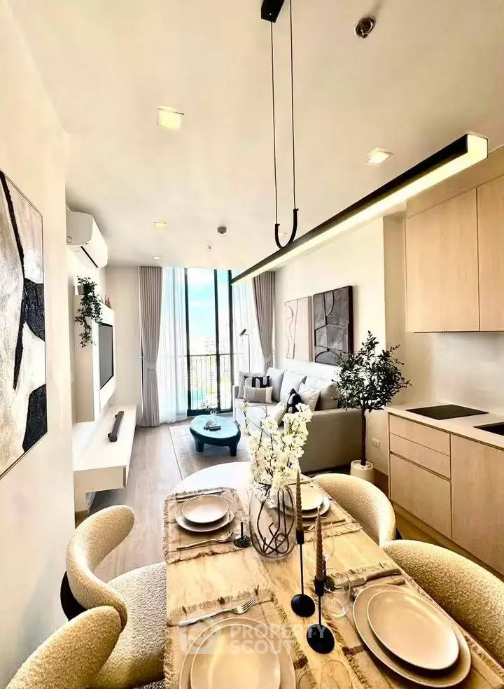 Modern open-plan living room and kitchen with elegant decor and natural light.