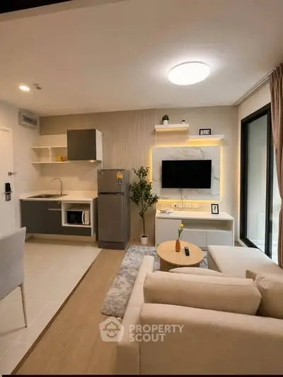 Modern living room with open kitchen, stylish decor, and cozy seating area in a contemporary apartment.