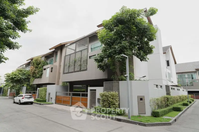 Modern townhouse with lush greenery and sleek design in a serene neighborhood.