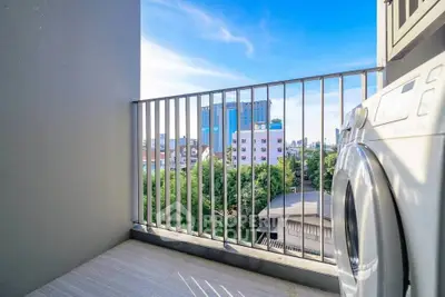 Charming balcony with city view and washing machine, perfect for urban living.