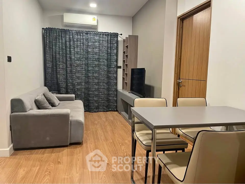 Modern living room with sleek furniture and wooden flooring in a cozy apartment setting.