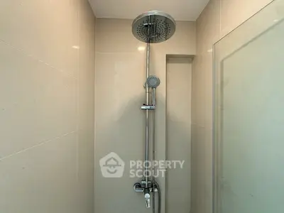 Modern bathroom shower with sleek chrome fixtures and beige tiles