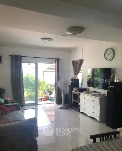 Bright living room with modern decor and garden view through sliding doors.