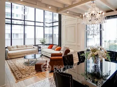 Luxurious living room with elegant chandelier and floor-to-ceiling windows in modern apartment.