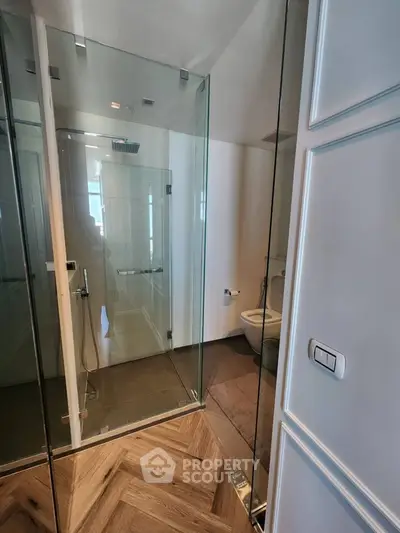 Modern bathroom with glass shower and elegant wood flooring