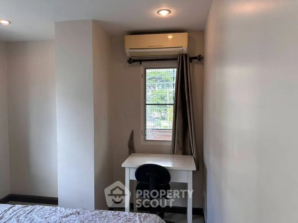 Cozy bedroom corner with desk and air conditioning, perfect for a compact study space.