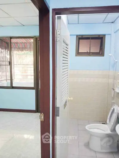 Cozy bathroom with adjacent room in a bright, airy home.