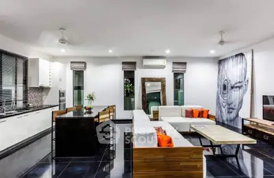 Modern open-plan living room with stylish decor and sleek kitchen area, perfect for contemporary living.