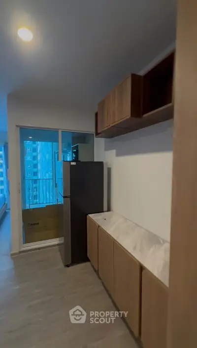 Modern kitchen with sleek cabinets and stainless steel fridge in urban apartment