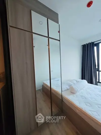 Modern bedroom with mirrored wardrobe and cozy bed setup