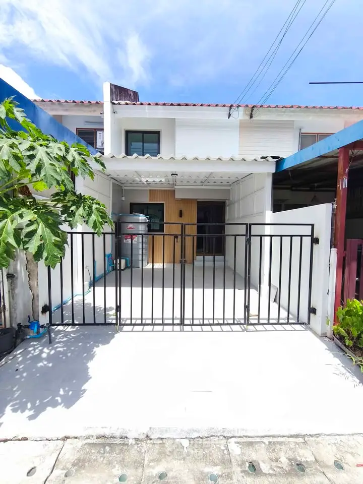 Charming townhouse with gated entrance and modern facade in a sunny neighborhood.