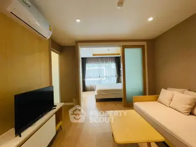 Modern living room with cozy sofa and view into a stylish bedroom